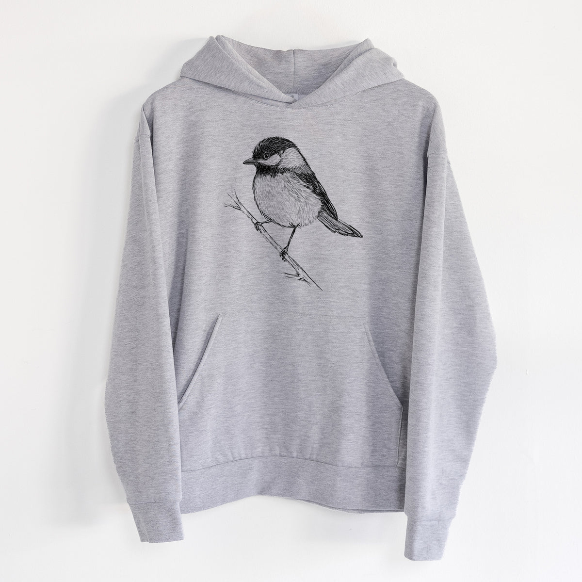 Black-capped Chickadee - Poecile atricapillus - Statement Midweight Hoodie in Heather Grey, hanging on a white wall, with a front kangaroo pocket and no drawcords.