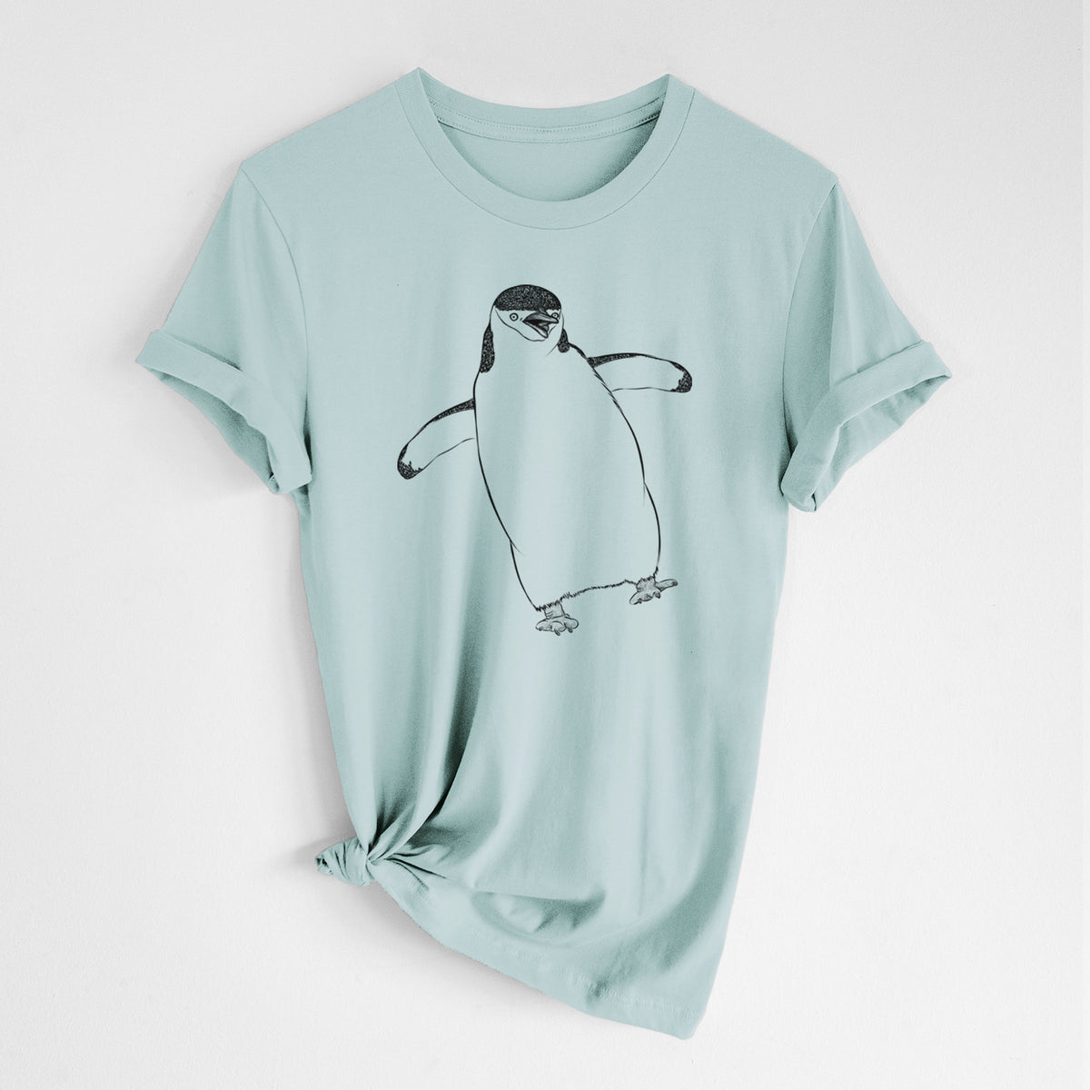 Dusty blue lightweight cotton t-shirt laid flat with the sleeves rolled, printed with a black ink illustration of a chinstrap penguin standing with its flippers out.