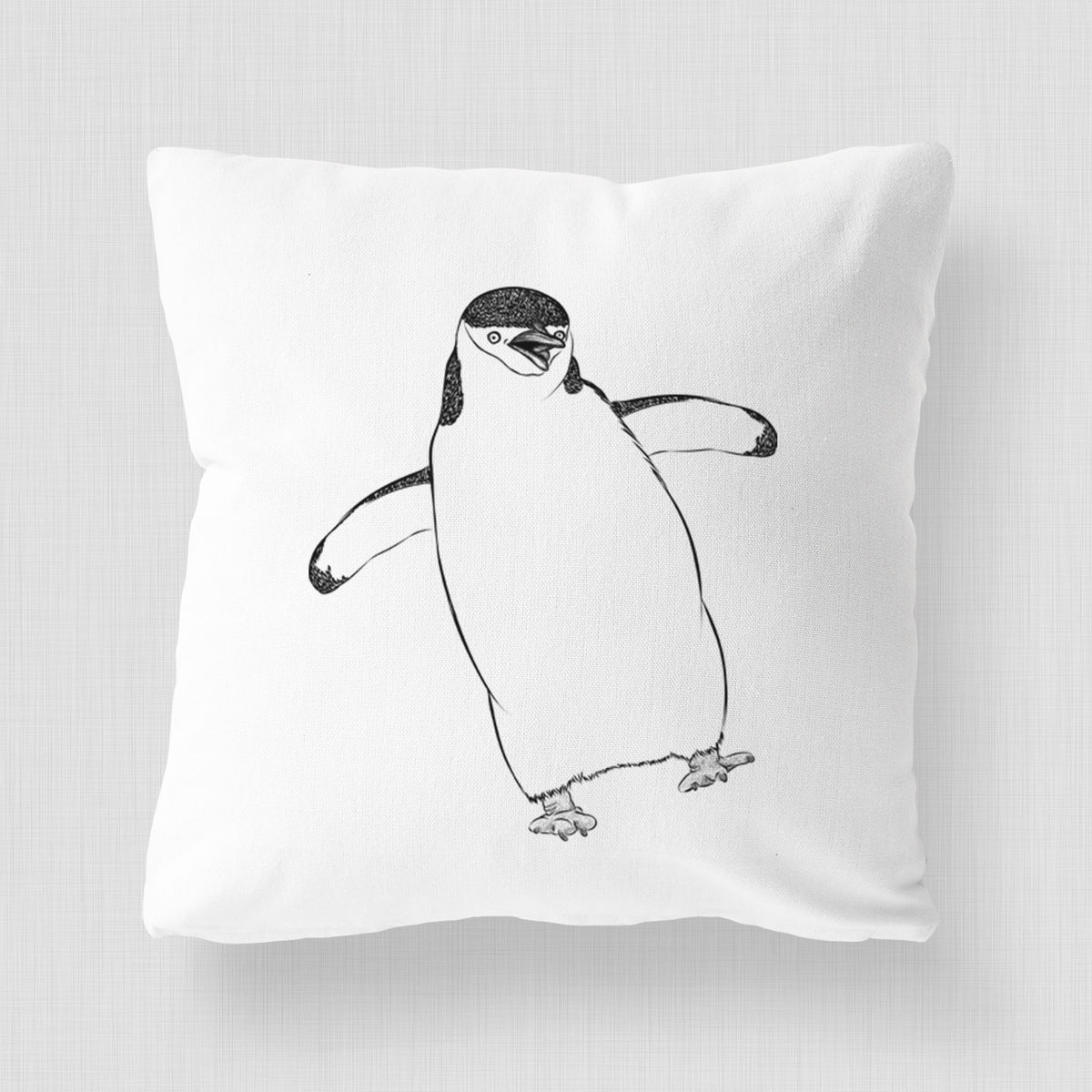 White pillow cover printed with a black ink illustration of a chinstrap penguin standing with its flippers out.