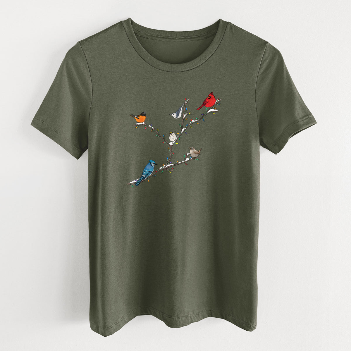 Military green women's relaxed fit cotton t-shirt laid flat, printed with a full-color illustration of winter backyard birds, including a cardinal, blue jay and robin, perched on bare branches.