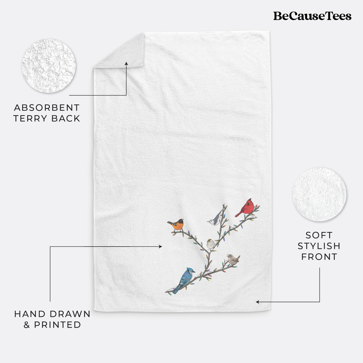 White hand towel printed with a full-color illustration of winter backyard birds, including a cardinal, blue jay and robin, perched on bare branches.