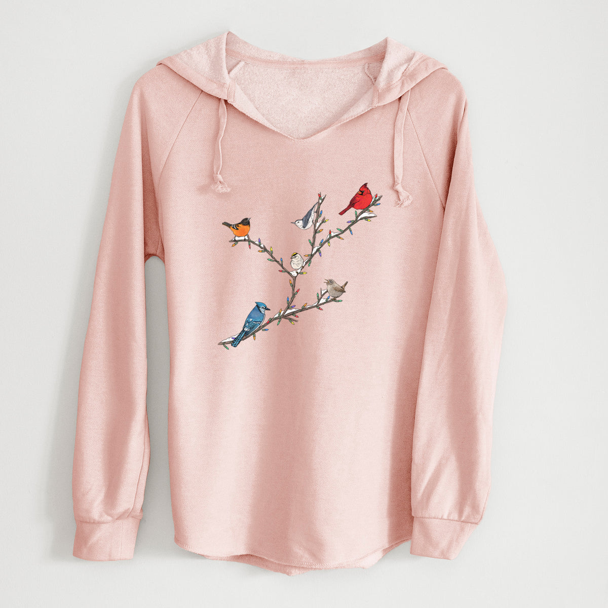 Blush pink women's Cali Wave hooded sweatshirt laid flat, printed with a full-color illustration of winter backyard birds, including a cardinal, blue jay and robin, perched on bare branches.