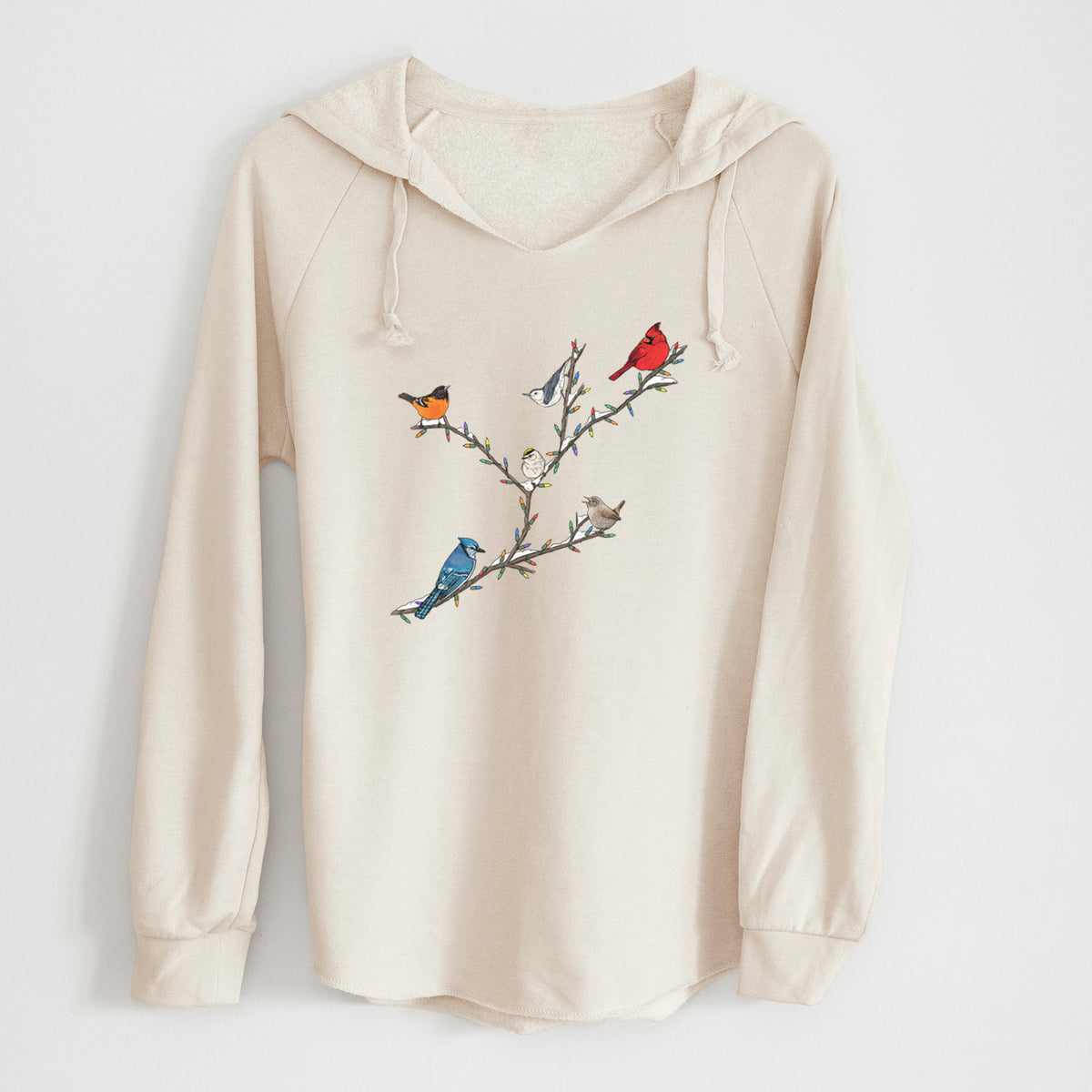 Bone cream women's Cali Wave hooded sweatshirt laid flat, printed with a full-color illustration of winter backyard birds, including a cardinal, blue jay and robin, perched on bare branches.