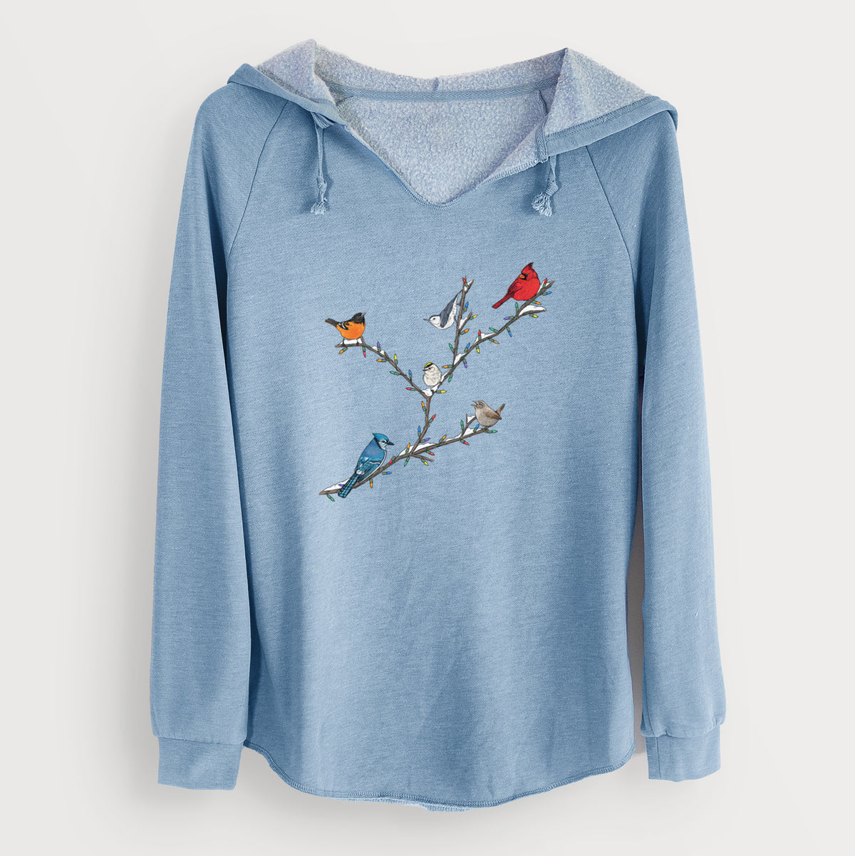 Misty blue women's Cali Wave hooded sweatshirt laid flat, printed with a full-color illustration of winter backyard birds, including a cardinal, blue jay and robin, perched on bare branches.