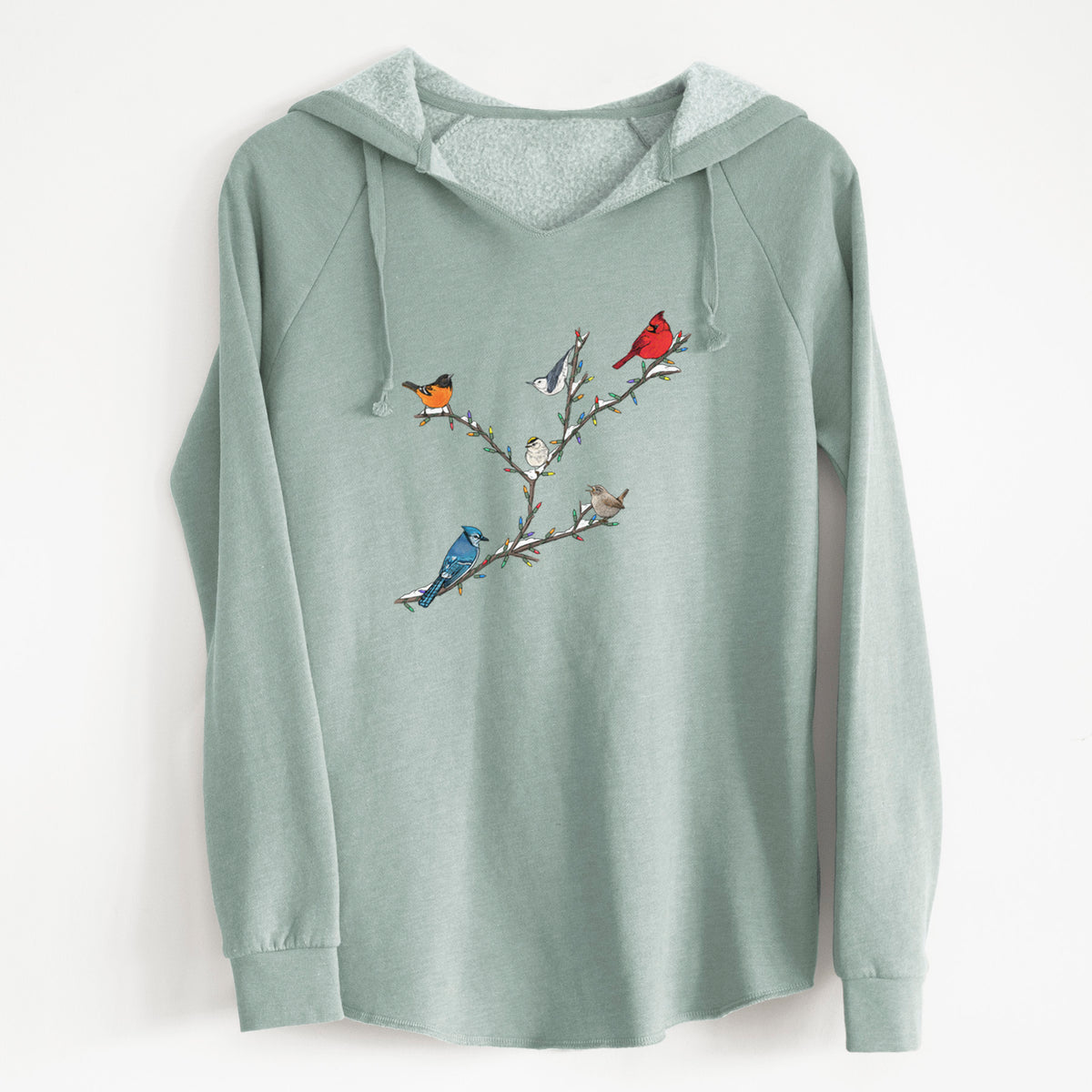 Sage green women's Cali Wave hooded sweatshirt laid flat, printed with a full-color illustration of winter backyard birds, including a cardinal, blue jay and robin, perched on bare branches.