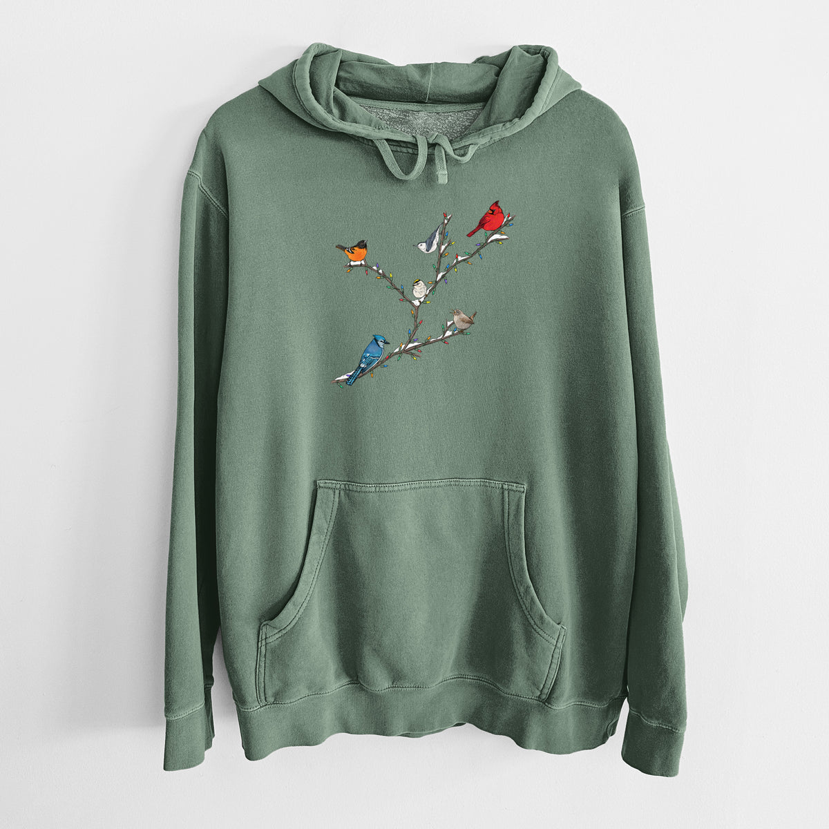 Alpine green pigment dyed hoodie laid flat, printed with a full-color illustration of winter backyard birds, including a cardinal, blue jay and robin, perched on bare branches.