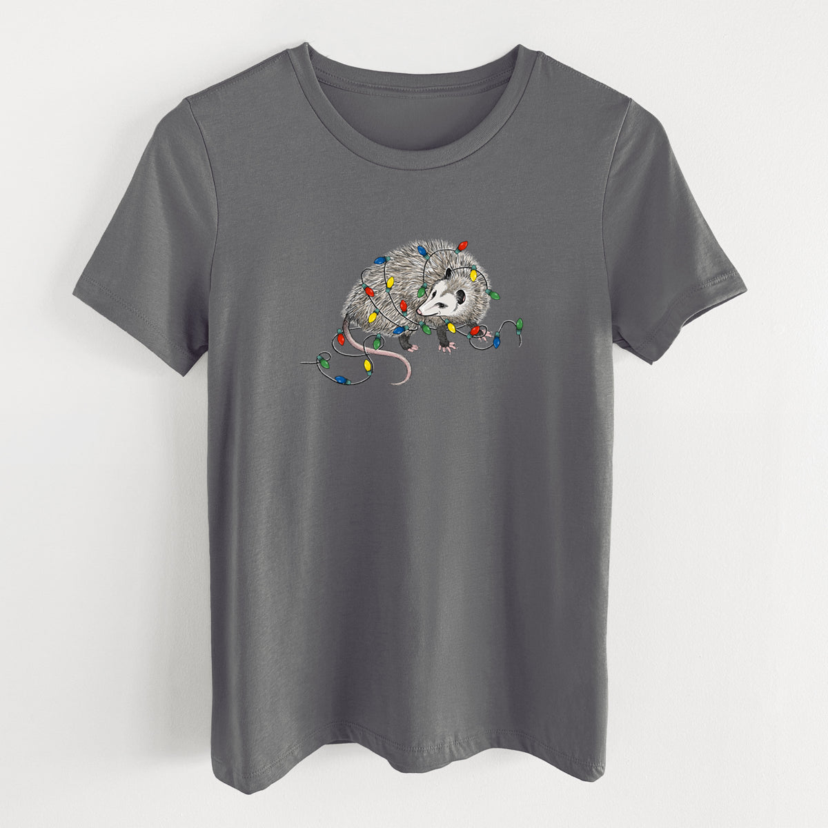 Asphalt women's relaxed fit cotton t-shirt laid flat, printed with a black ink opossum tangled in a string of colorful holiday lights.