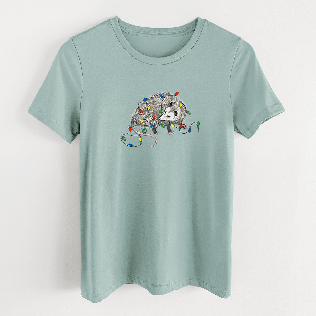 Dusty blue women's relaxed fit cotton t-shirt laid flat, printed with a black ink opossum tangled in a string of colorful holiday lights.
