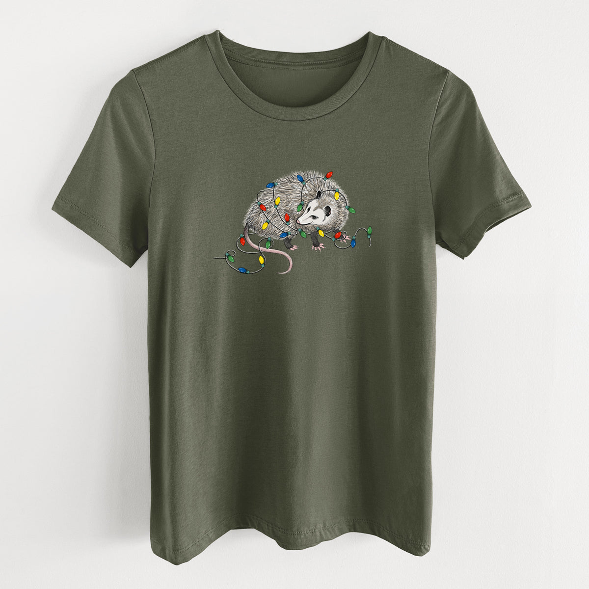 Military green women's relaxed fit cotton t-shirt laid flat, printed with a black ink opossum tangled in a string of colorful holiday lights.