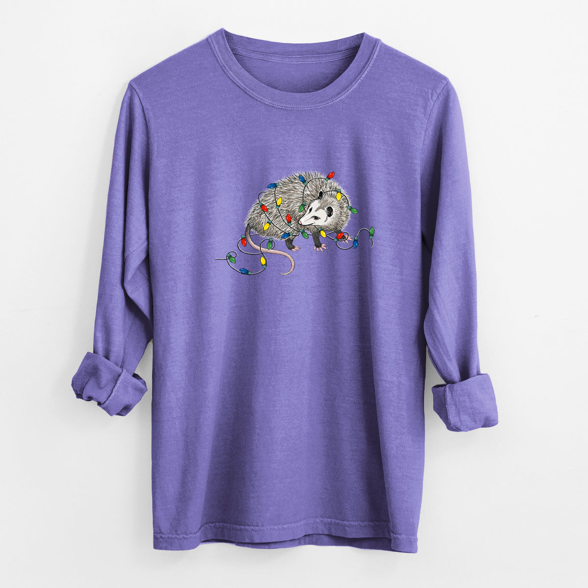 Violet purple Comfort Colors long sleeve shirt laid flat with the cuffs rolled, printed with a black ink opossum tangled in a string of colorful holiday lights.