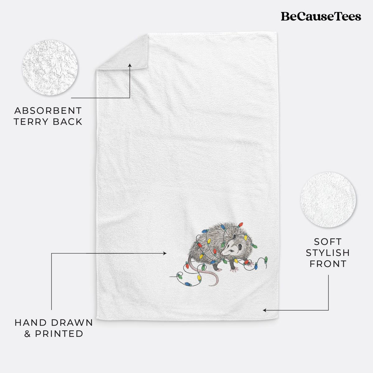 White hand towel printed with a black ink opossum tangled in a string of colorful holiday lights.