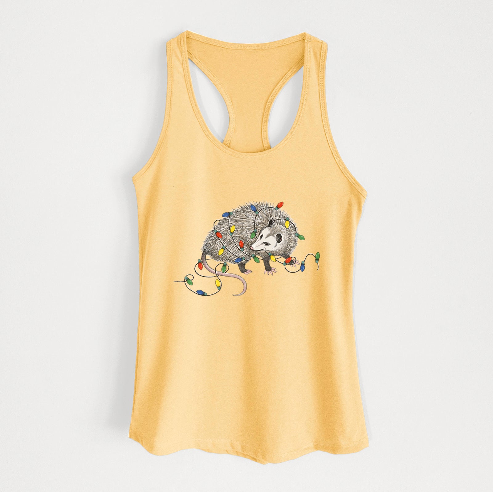 Banana cream women's racerback tank top laid flat, printed with a black ink opossum tangled in a string of colorful holiday lights.