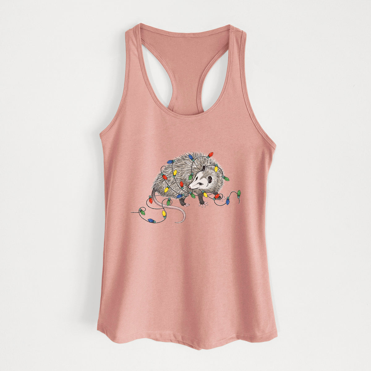 Desert pink women's racerback tank top laid flat, printed with a black ink opossum tangled in a string of colorful holiday lights.