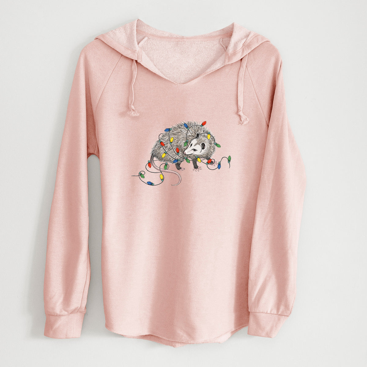 Blush pink women's Cali Wave hooded sweatshirt laid flat, printed with a black ink opossum tangled in a string of colorful holiday lights.