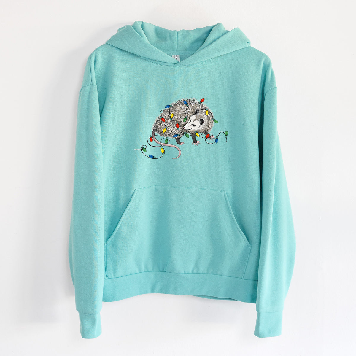 Christmas Opossum - Statement Midweight Hoodie in Seafoam, hanging on a white wall, with a front kangaroo pocket and no drawcords.