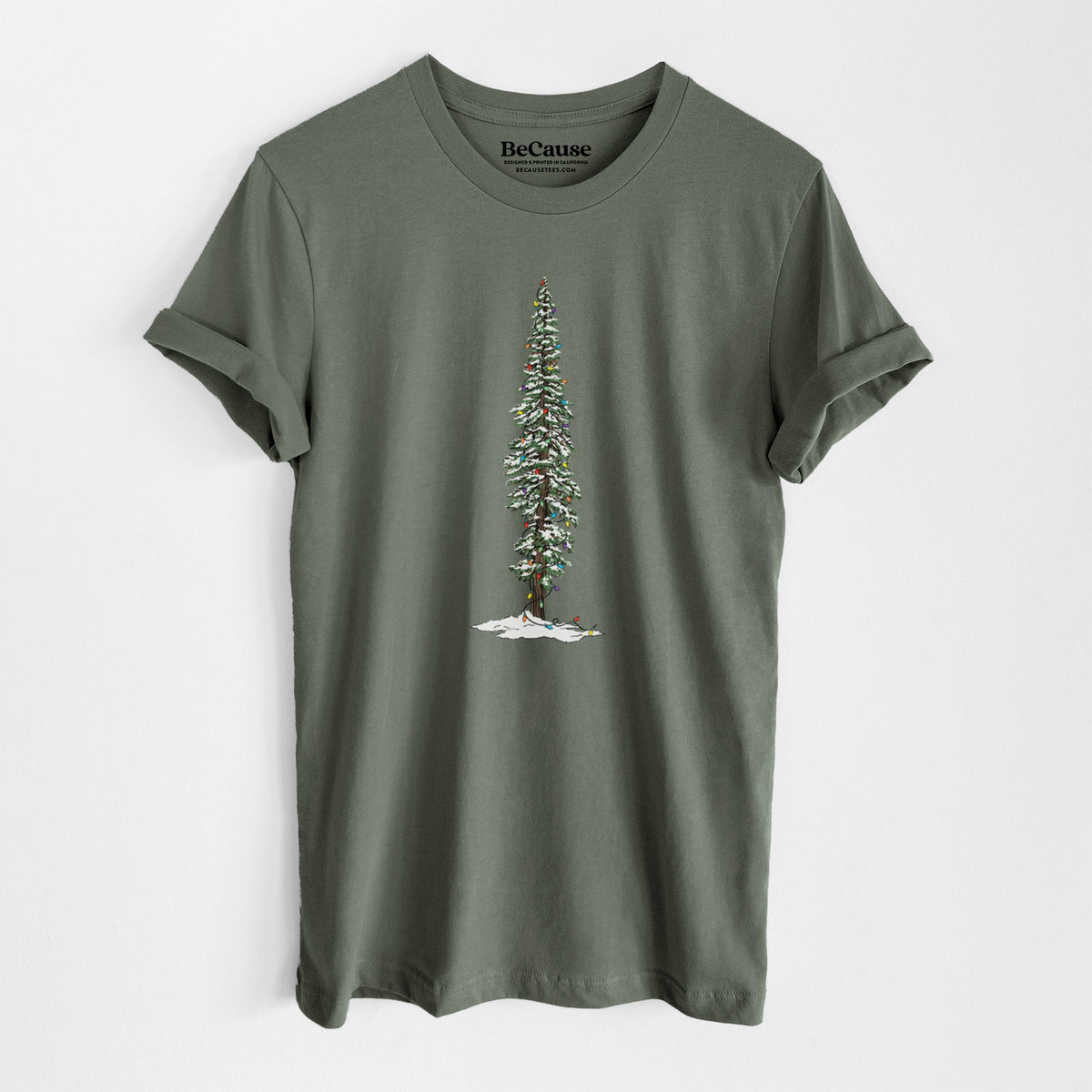 Military green lightweight cotton t-shirt laid flat, printed with a full-color illustration of a tall redwood tree dusted with snow and strung with holiday lights.