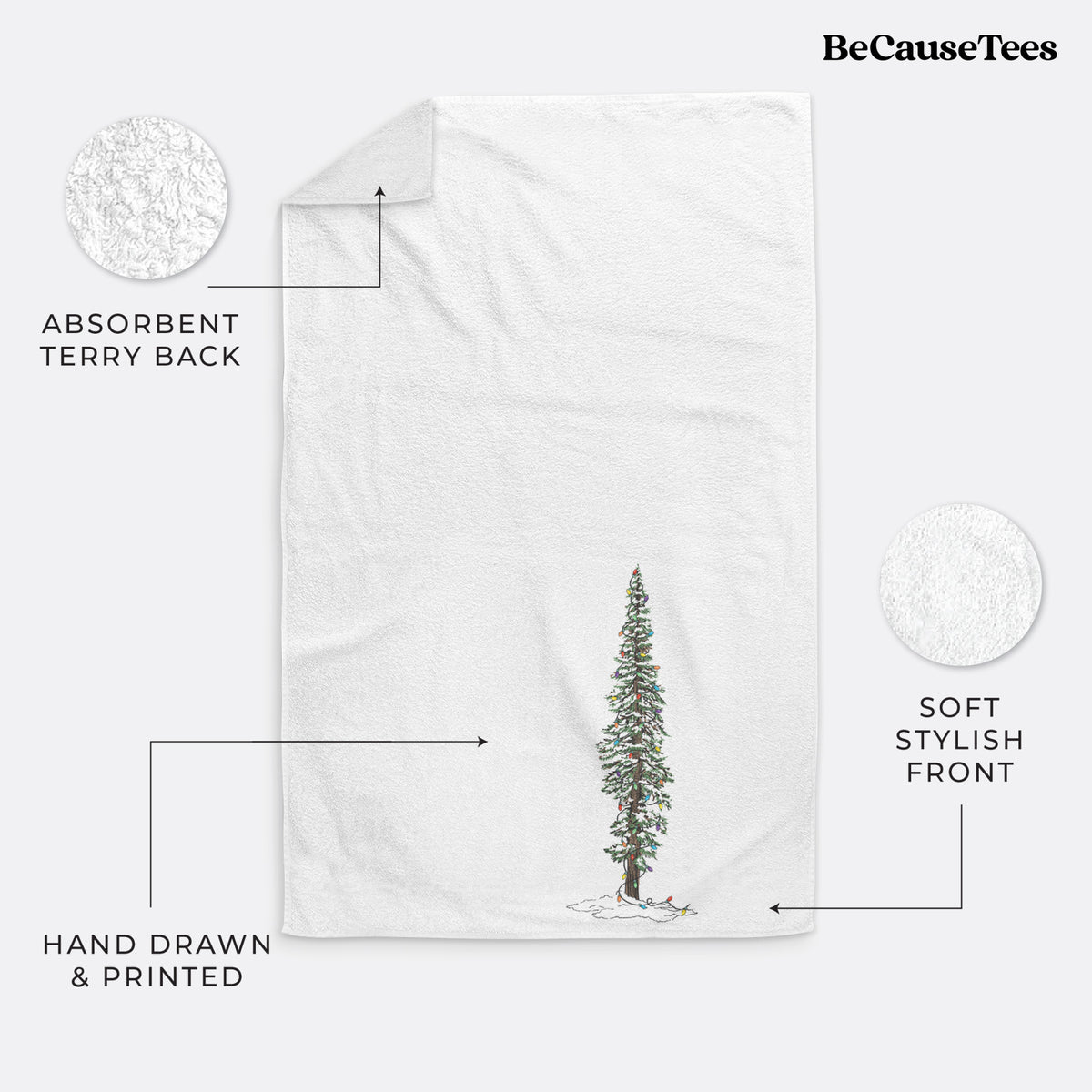 White hand towel printed with a full-color illustration of a tall redwood tree dusted with snow and strung with holiday lights.