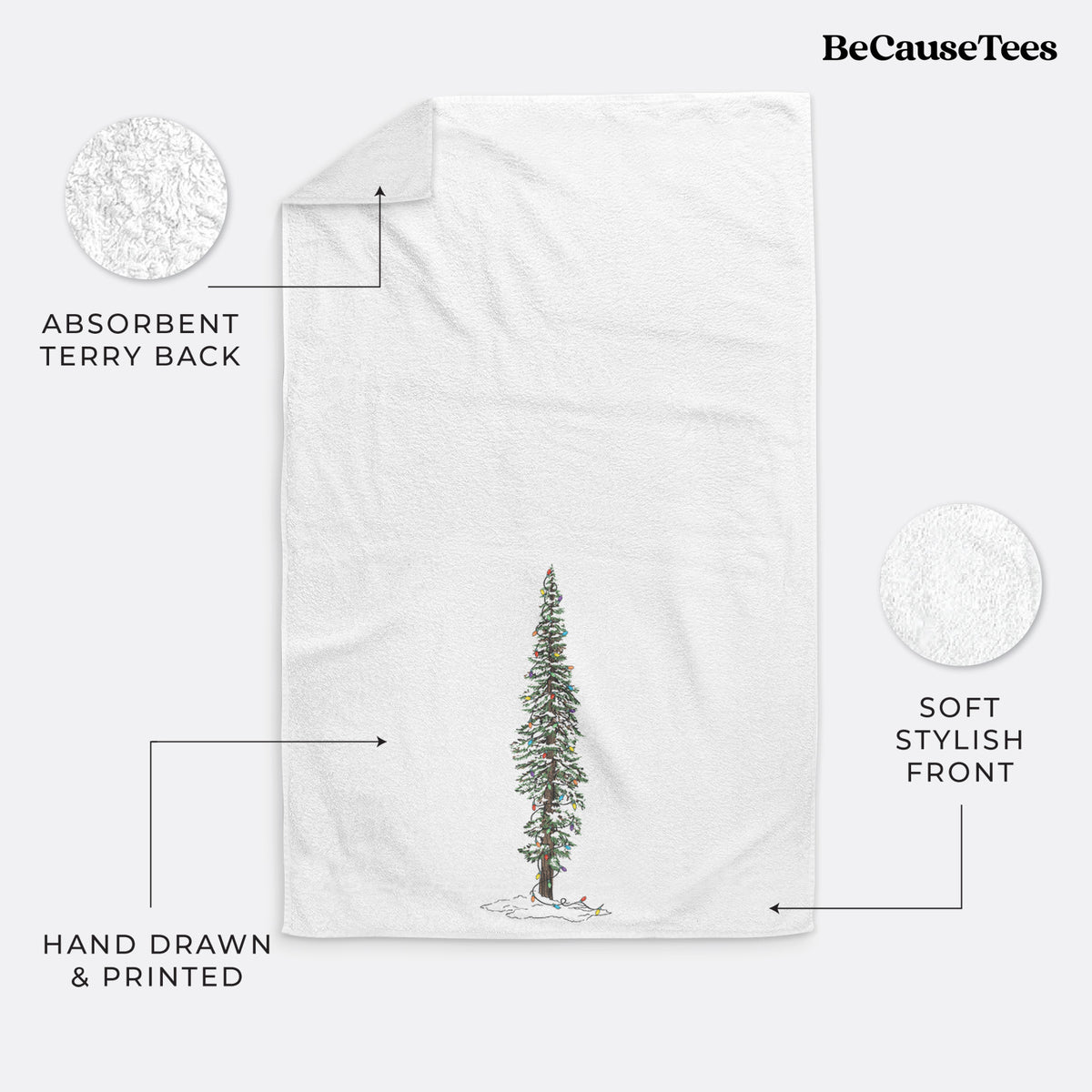 White hand towel printed with a full-color illustration of a tall redwood tree dusted with snow and strung with holiday lights.