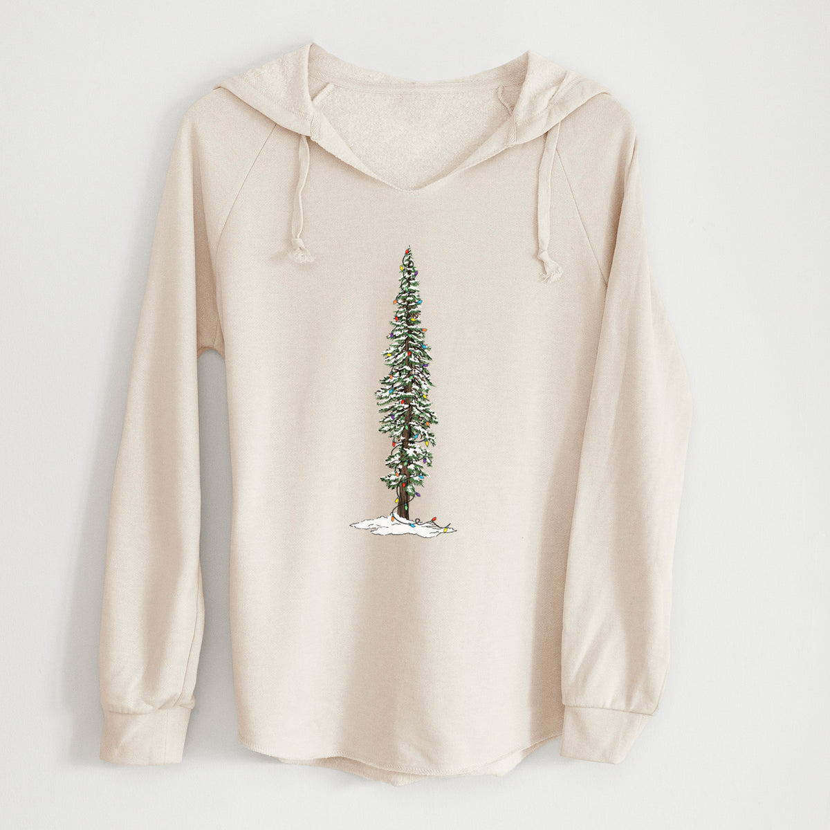 Bone cream women's Cali Wave hooded sweatshirt laid flat, printed with a full-color illustration of a tall redwood tree dusted with snow and strung with holiday lights.