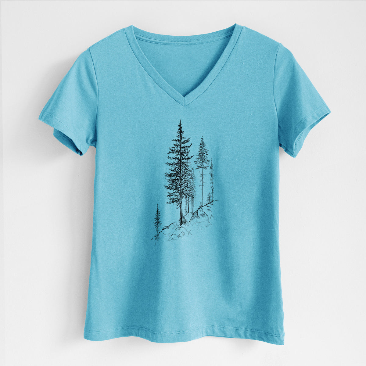 Turquoise women's relaxed fit cotton V-neck t-shirt laid flat, printed with a black ink illustration of tall pine trees growing from a rocky cliff.