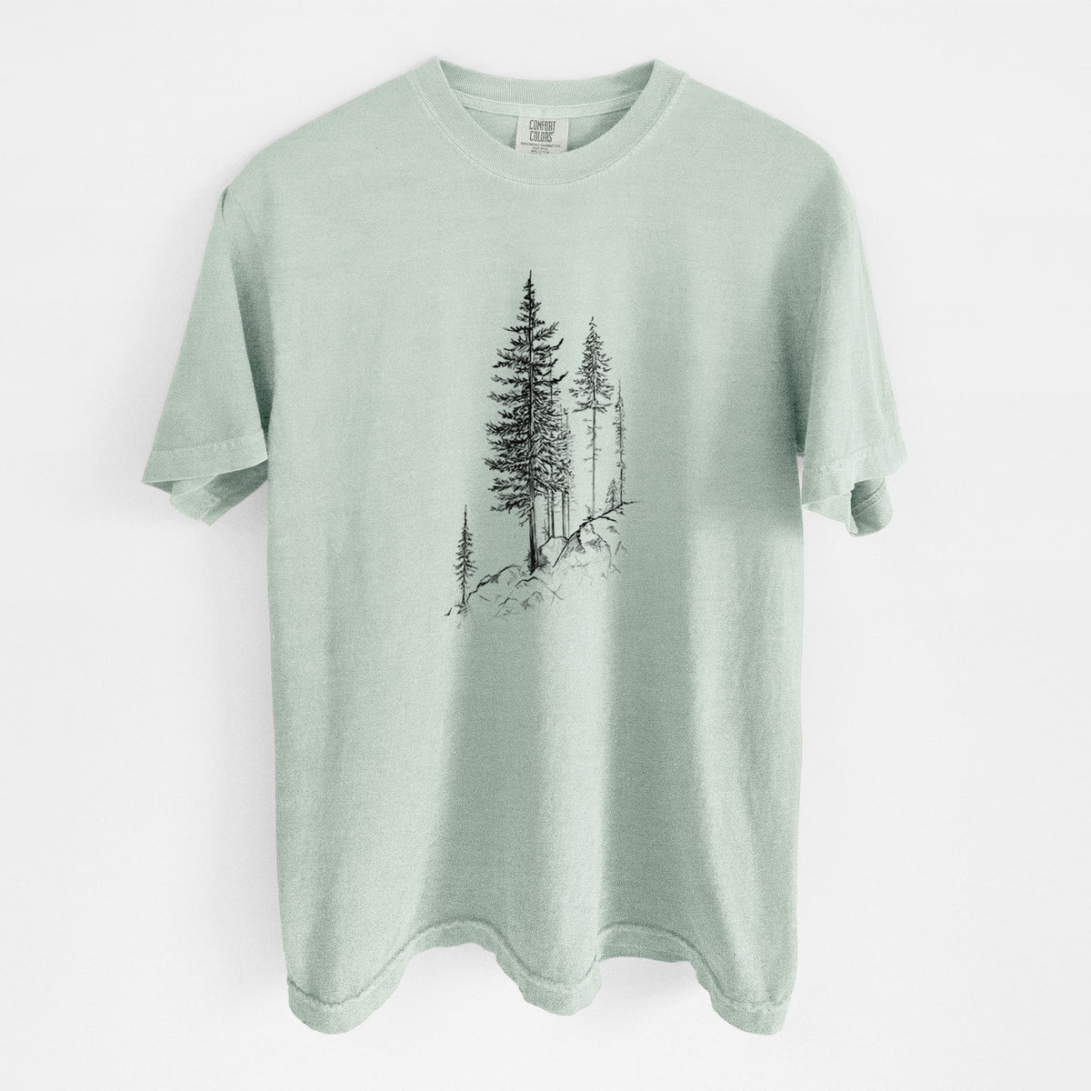 Bay green Comfort Colors t-shirt laid flat, printed with a black ink illustration of tall pine trees growing from a rocky cliff.