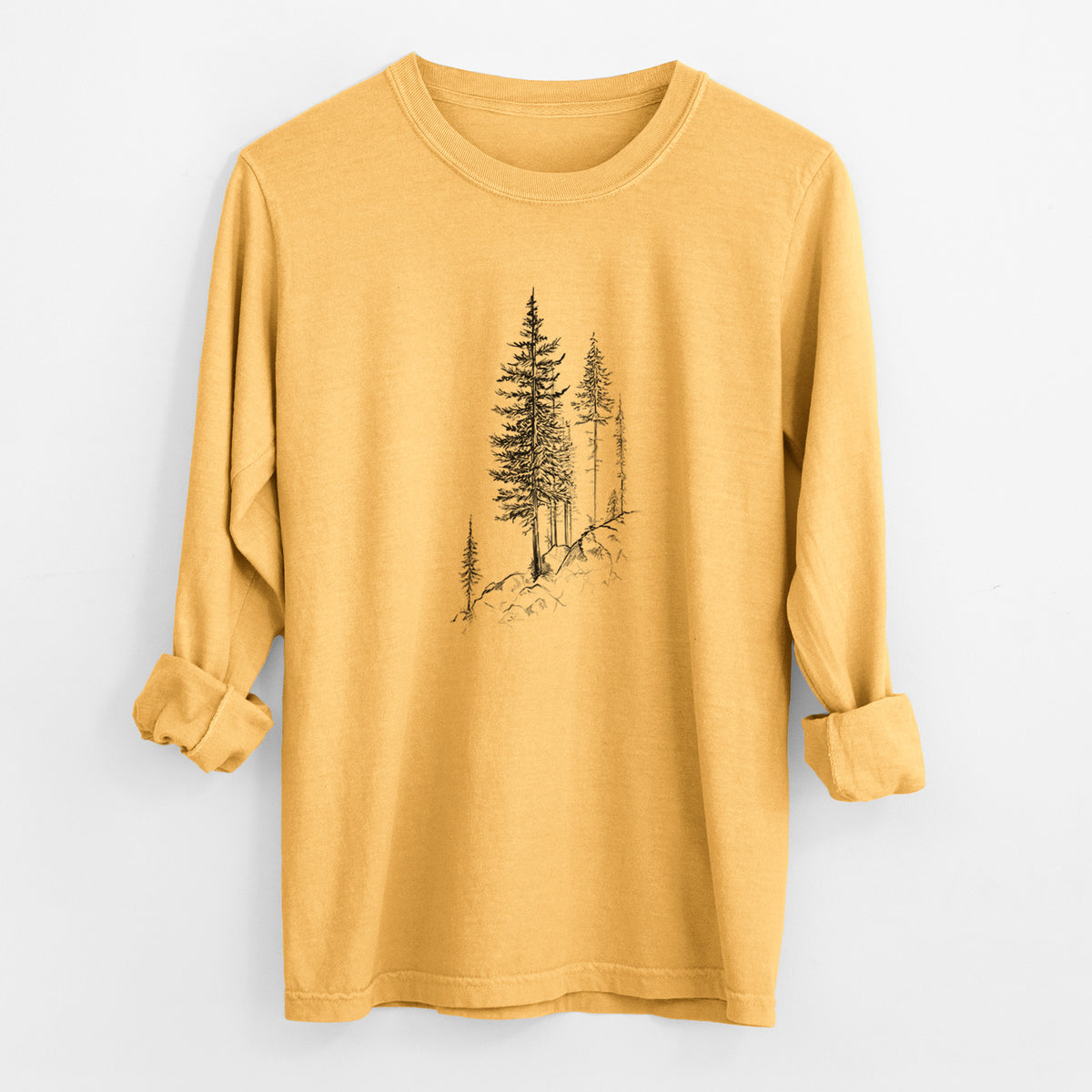 Golden wheat yellow Comfort Colors long sleeve shirt laid flat with the cuffs rolled, printed with a black ink illustration of tall pine trees growing from a rocky cliff.