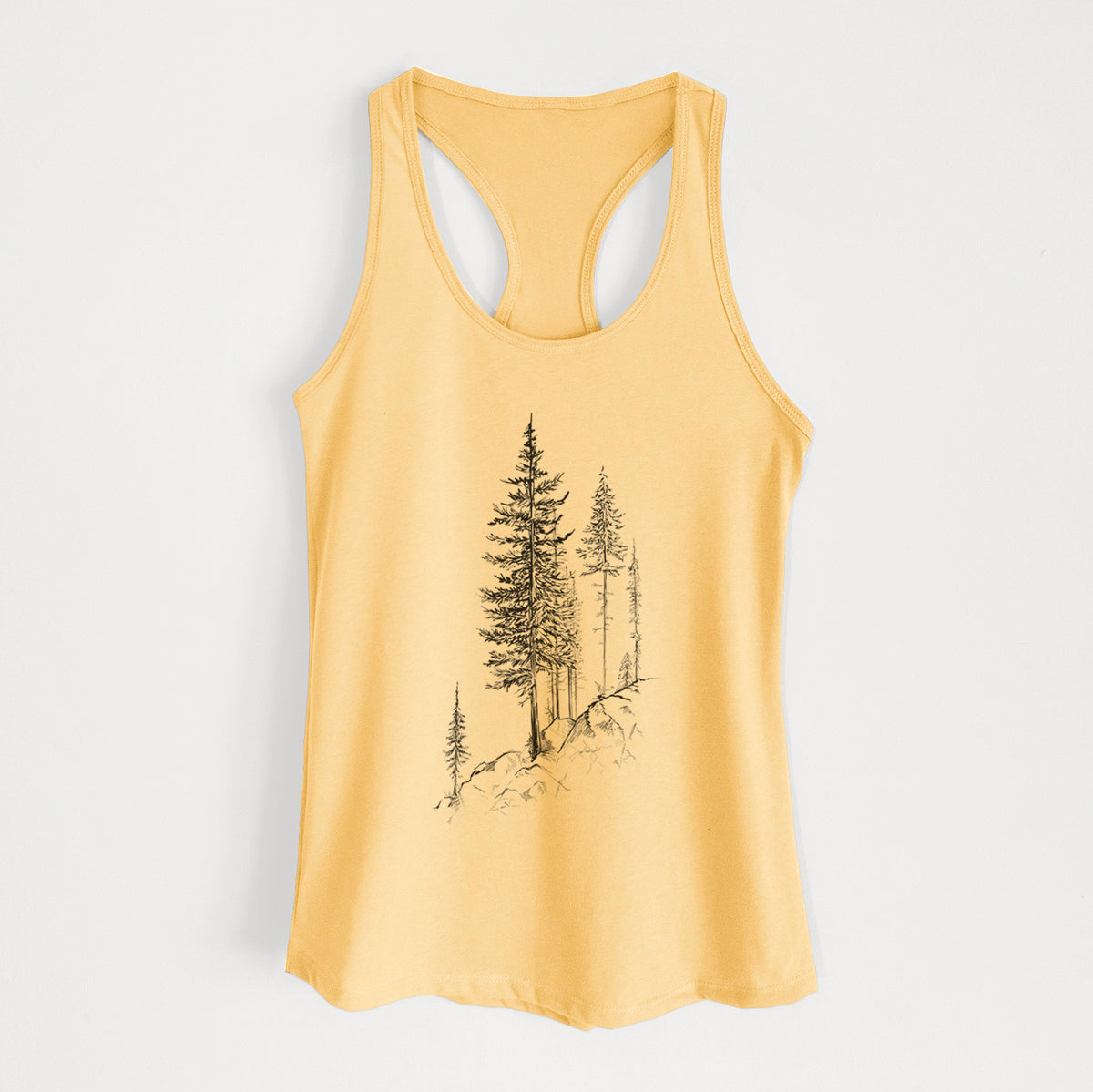 Banana cream women's racerback tank top laid flat, printed with a black ink illustration of tall pine trees growing from a rocky cliff.