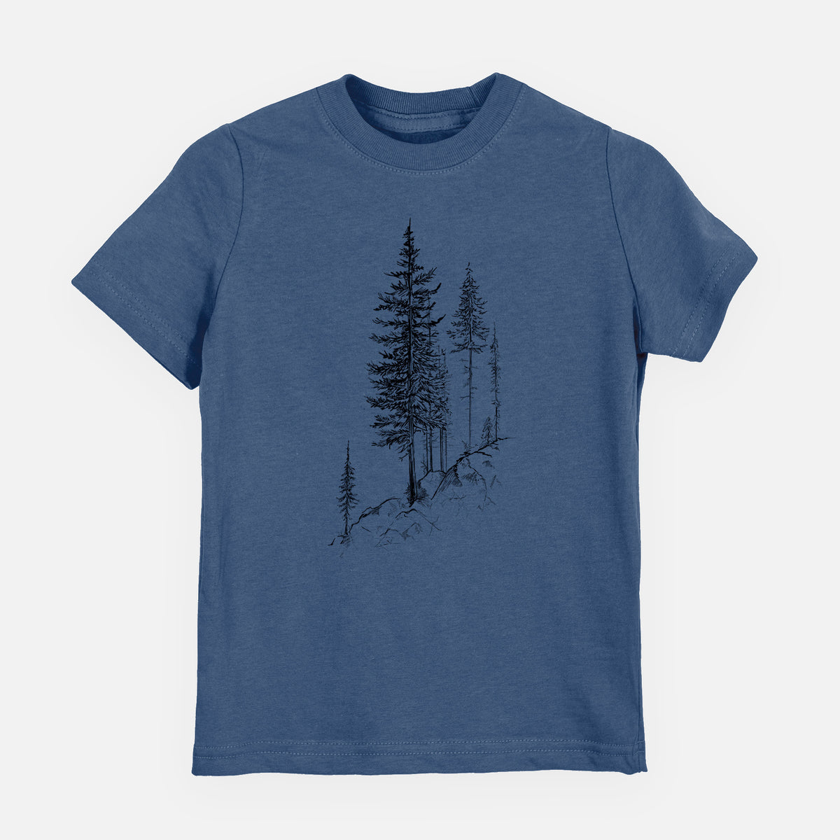 Indigo blue youth t-shirt laid flat, printed with a black ink illustration of tall pine trees growing from a rocky cliff.