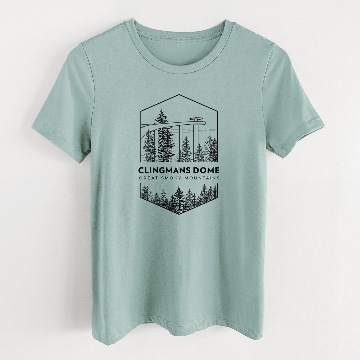 Dusty blue women's relaxed fit cotton t-shirt laid flat, printed with a black line art badge of the Clingmans Dome observation tower above a pine forest, with the words Clingmans Dome, Great Smoky Mountains.