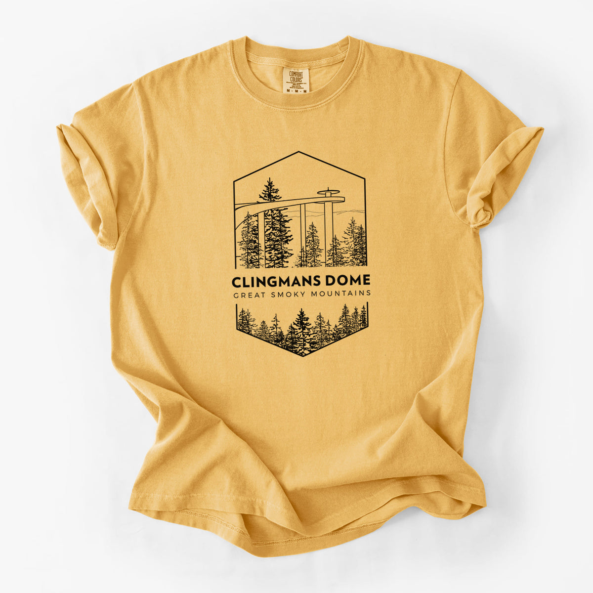 Golden wheat yellow Comfort Colors t-shirt laid flat, printed with a black line art badge of the Clingmans Dome observation tower above a pine forest, with the words Clingmans Dome, Great Smoky Mountains.