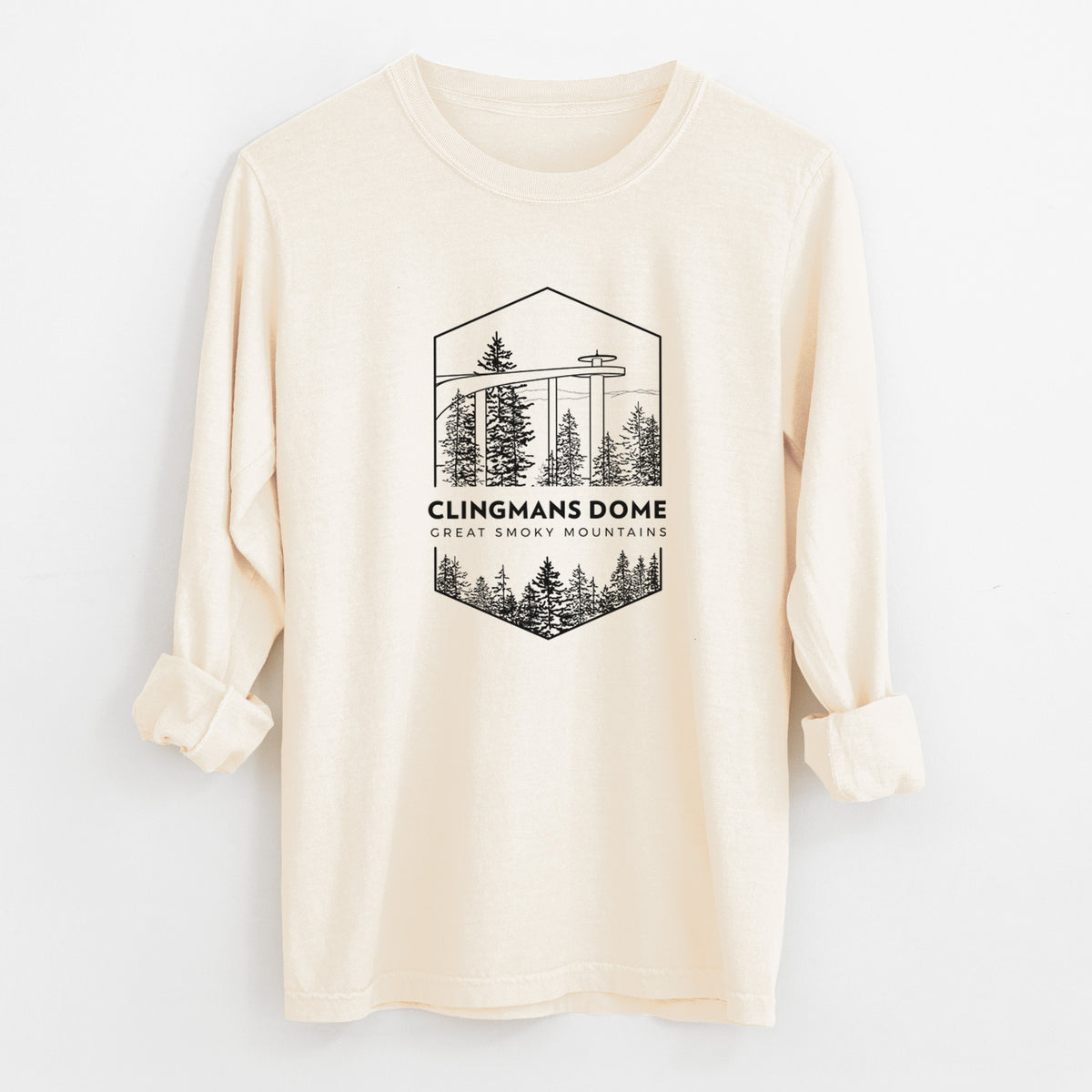 Ivory Comfort Colors long sleeve shirt laid flat with the cuffs rolled, printed with a black line art badge of the Clingmans Dome observation tower above a pine forest, with the words Clingmans Dome, Great Smoky Mountains.