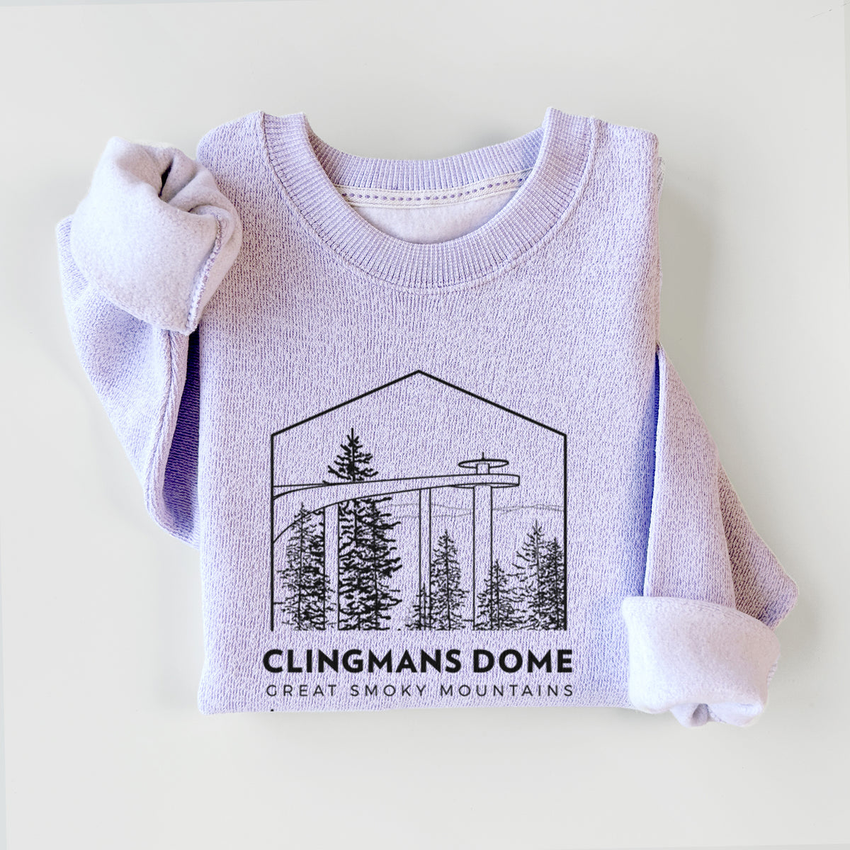 Ice purple knit sweatshirt printed with a black line art badge of the Clingmans Dome observation tower above a pine forest, with the words Clingmans Dome, Great Smoky Mountains, styled flat.