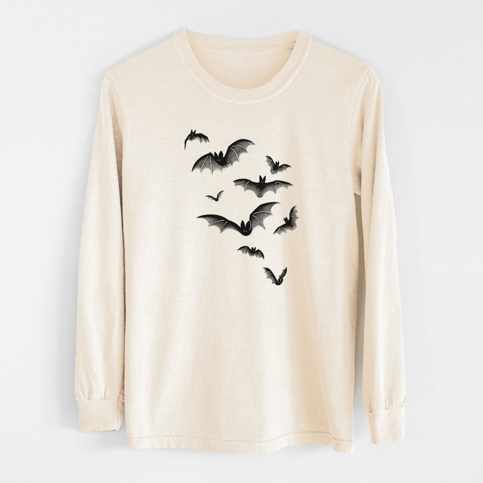 Ivory Comfort Colors long sleeve shirt laid flat, printed with a black ink illustration of a cloud of bats in flight.