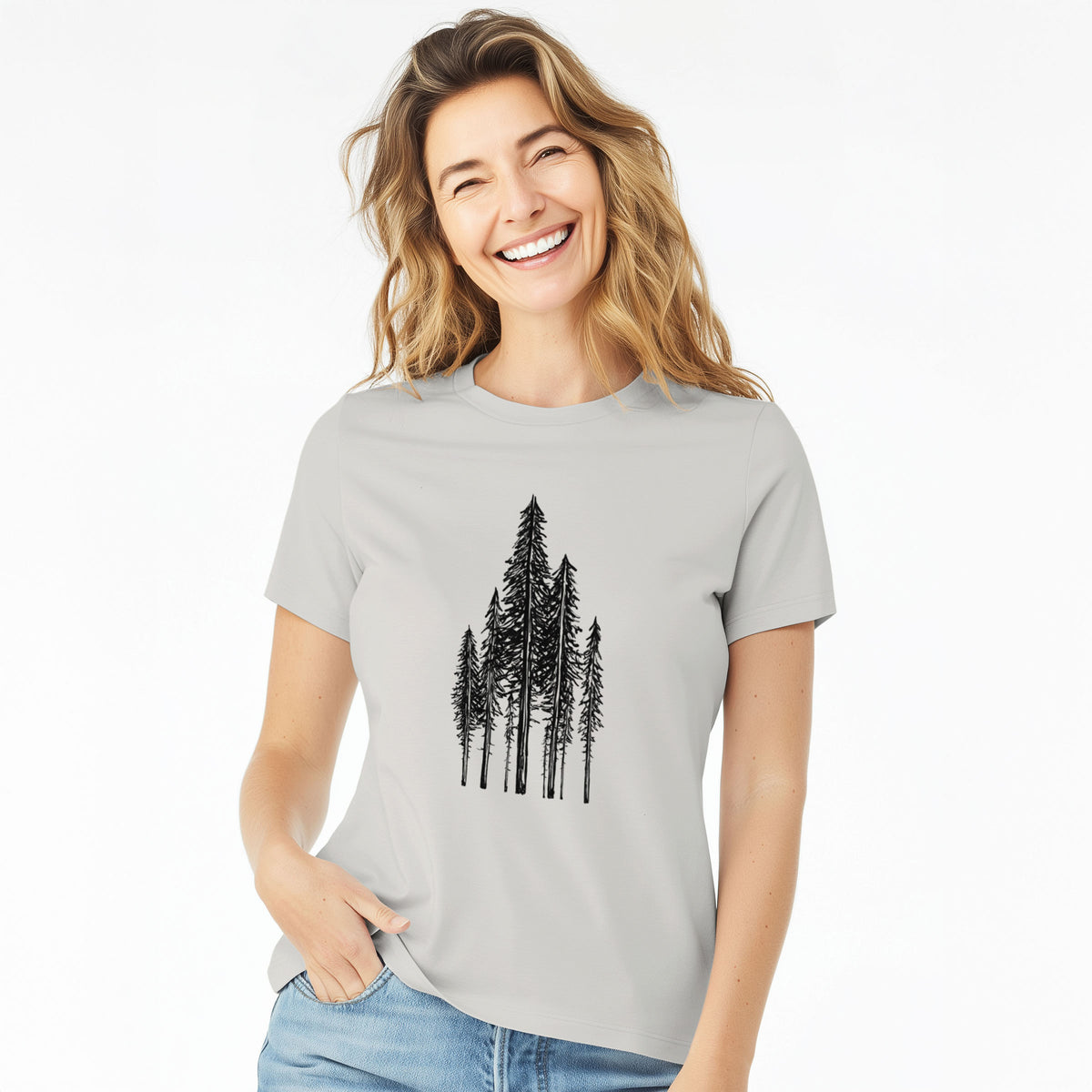 Woman wearing a lunar grey women's relaxed fit cotton t-shirt printed with a black ink illustration of a stand of tall coastal redwood trees with slender trunks and layered branches.