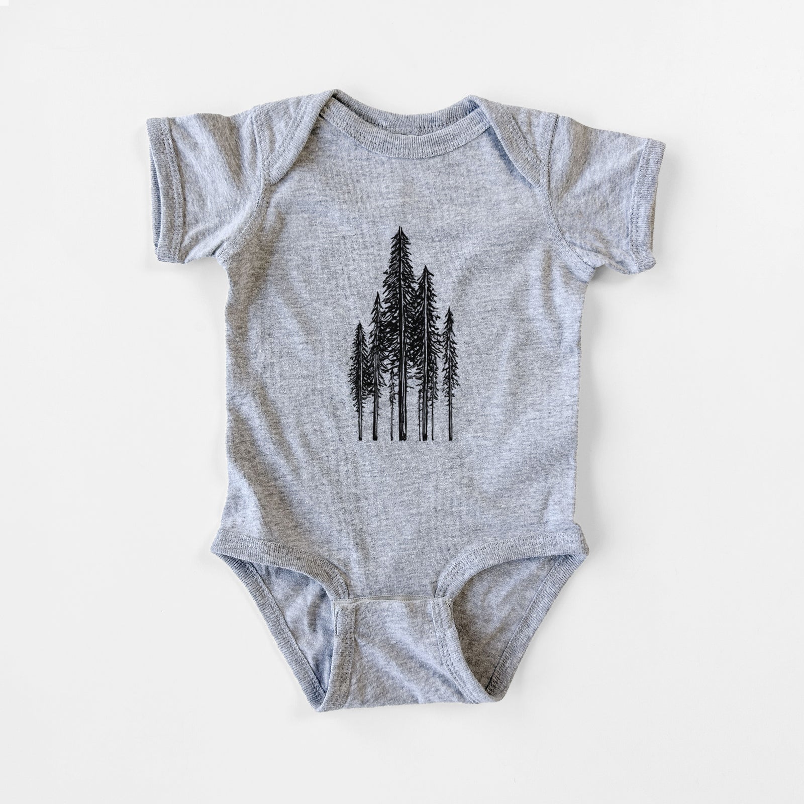 Grey baby bodysuit laid flat, printed with a black ink illustration of a stand of tall coastal redwood trees with slender trunks and layered branches.