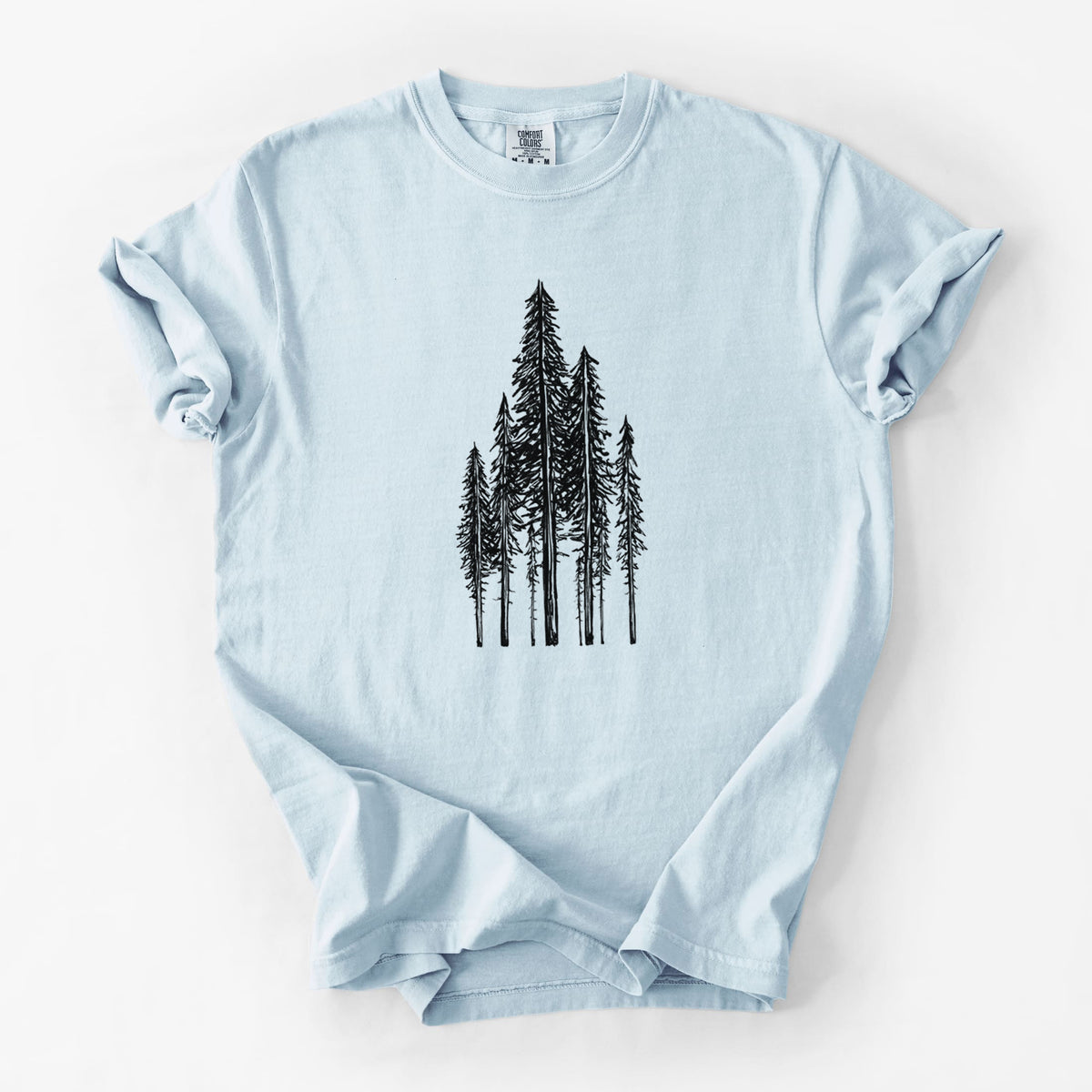Chambray blue Comfort Colors t-shirt laid flat, printed with a black ink illustration of a stand of tall coastal redwood trees with slender trunks and layered branches.