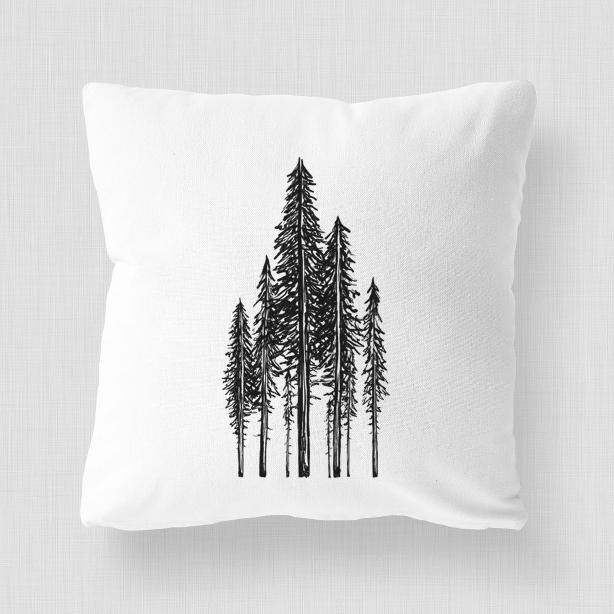 White pillow cover printed with a black ink illustration of a stand of tall coastal redwood trees with slender trunks and layered branches.