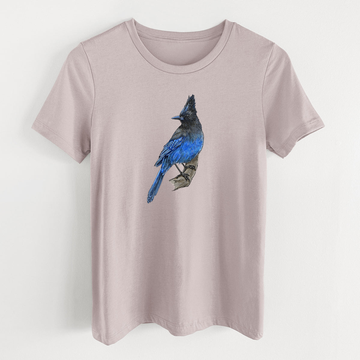 Pink gravel women's relaxed fit cotton t-shirt laid flat, printed with a full-color illustration of a Steller's jay perched with its dark crest raised.