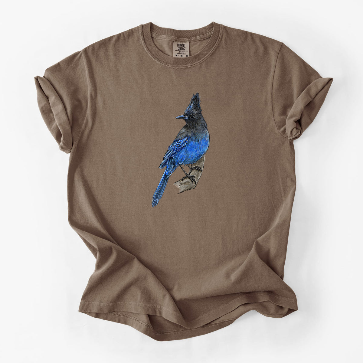 Espresso brown Comfort Colors t-shirt laid flat, printed with a full-color illustration of a Steller's jay perched with its dark crest raised.