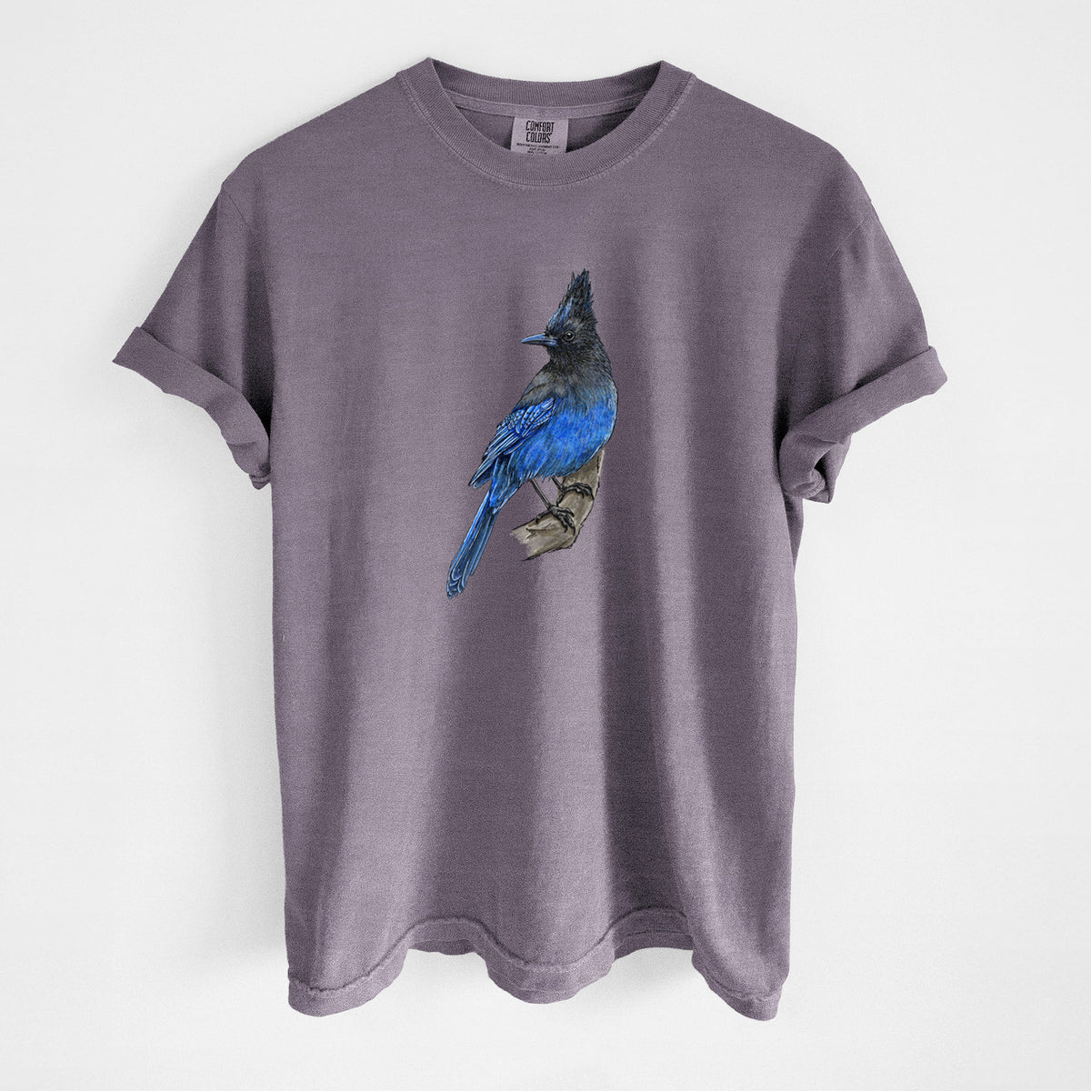 Wine red Comfort Colors t-shirt laid flat, printed with a full-color illustration of a Steller's jay perched with its dark crest raised.