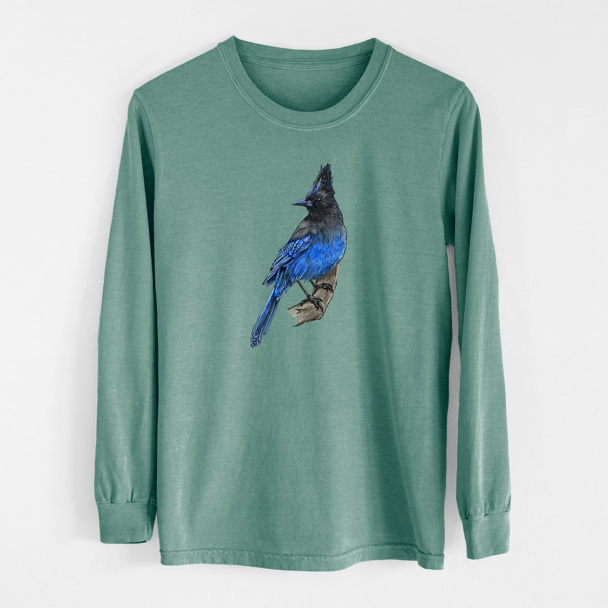 Pine green Comfort Colors long sleeve shirt laid flat, printed with a full-color illustration of a Steller's jay perched with its dark crest raised.