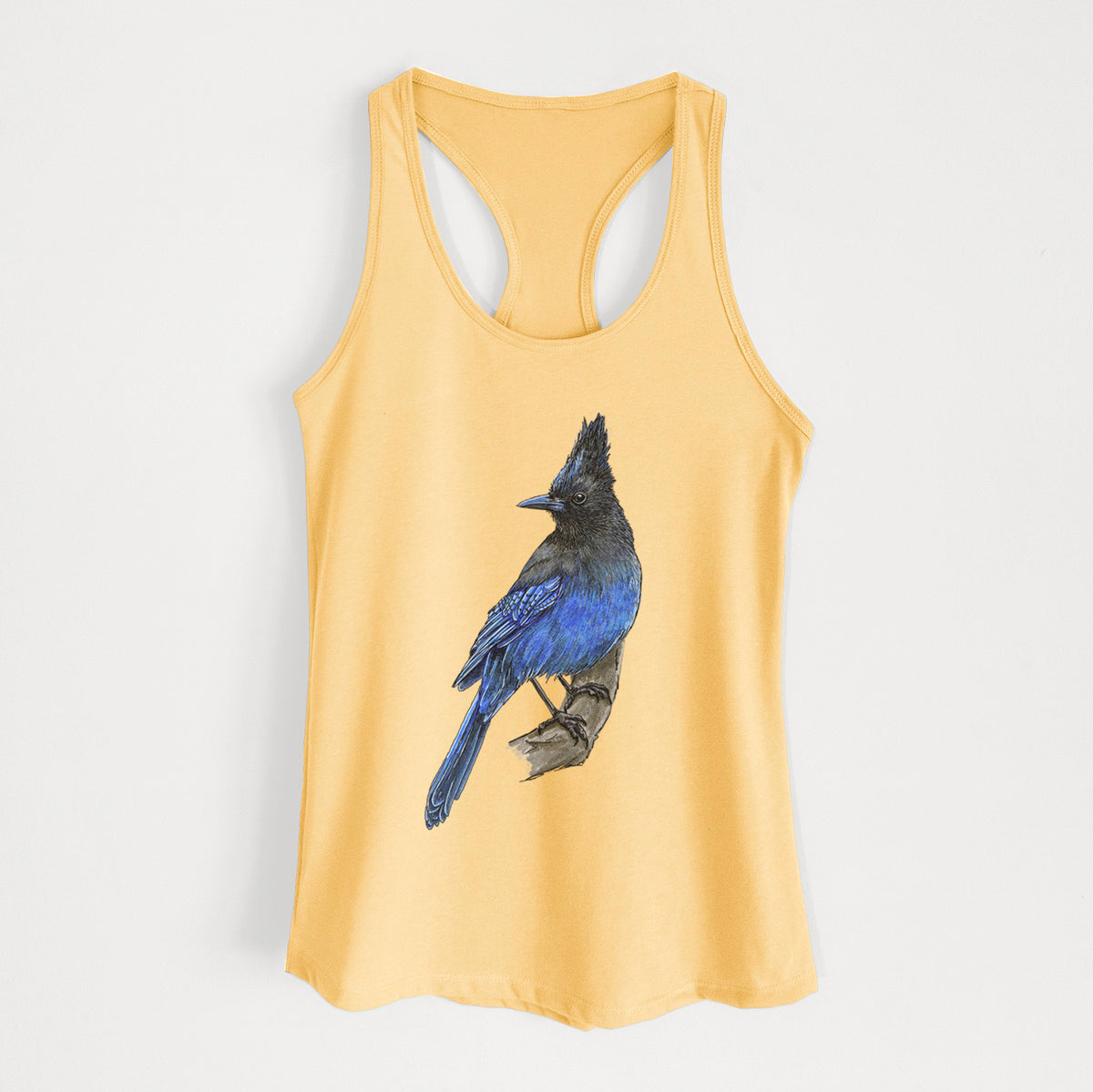 Banana cream women's racerback tank top laid flat, printed with a full-color illustration of a Steller's jay perched with its dark crest raised.