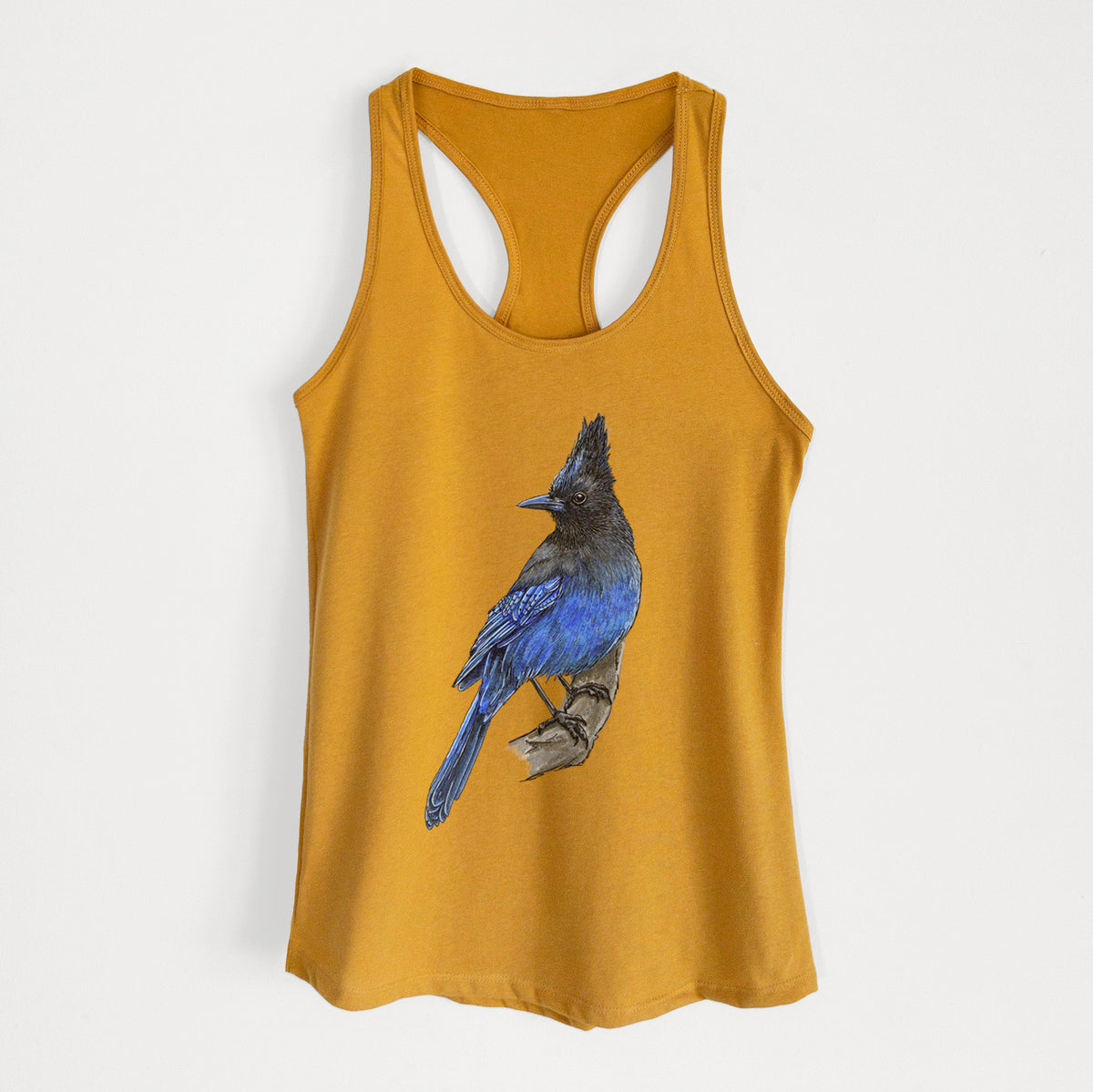 Gold women's racerback tank top laid flat, printed with a full-color illustration of a Steller's jay perched with its dark crest raised.