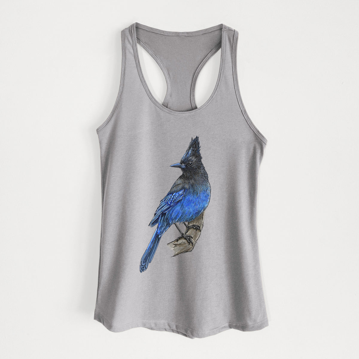 Heather grey women's racerback tank top laid flat, printed with a full-color illustration of a Steller's jay perched with its dark crest raised.