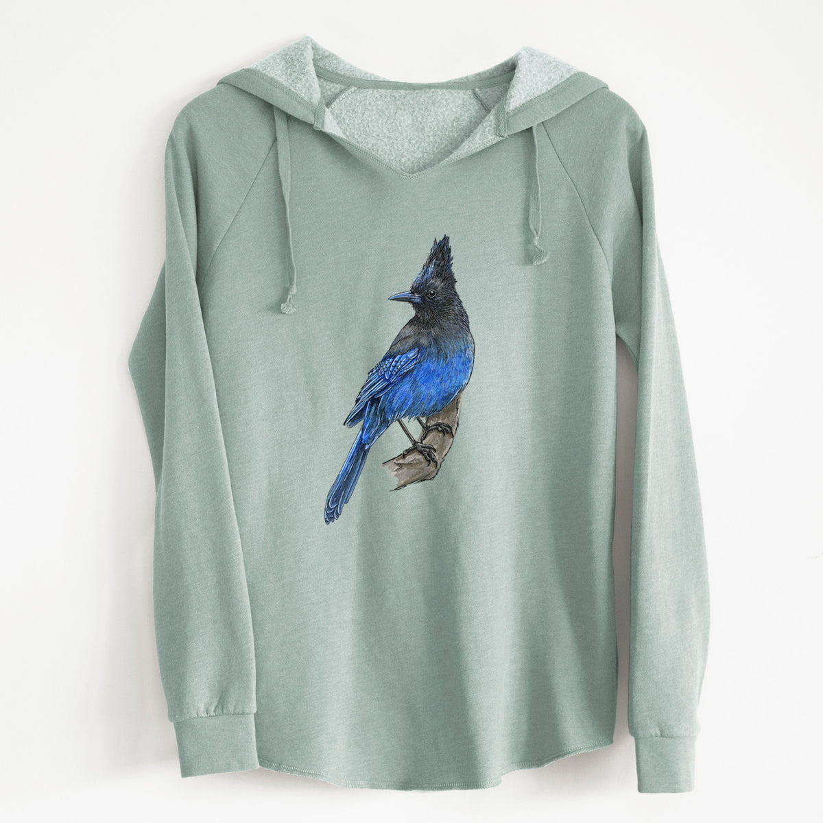 Sage green women's Cali Wave hooded sweatshirt laid flat, printed with a full-color illustration of a Steller's jay perched with its dark crest raised.