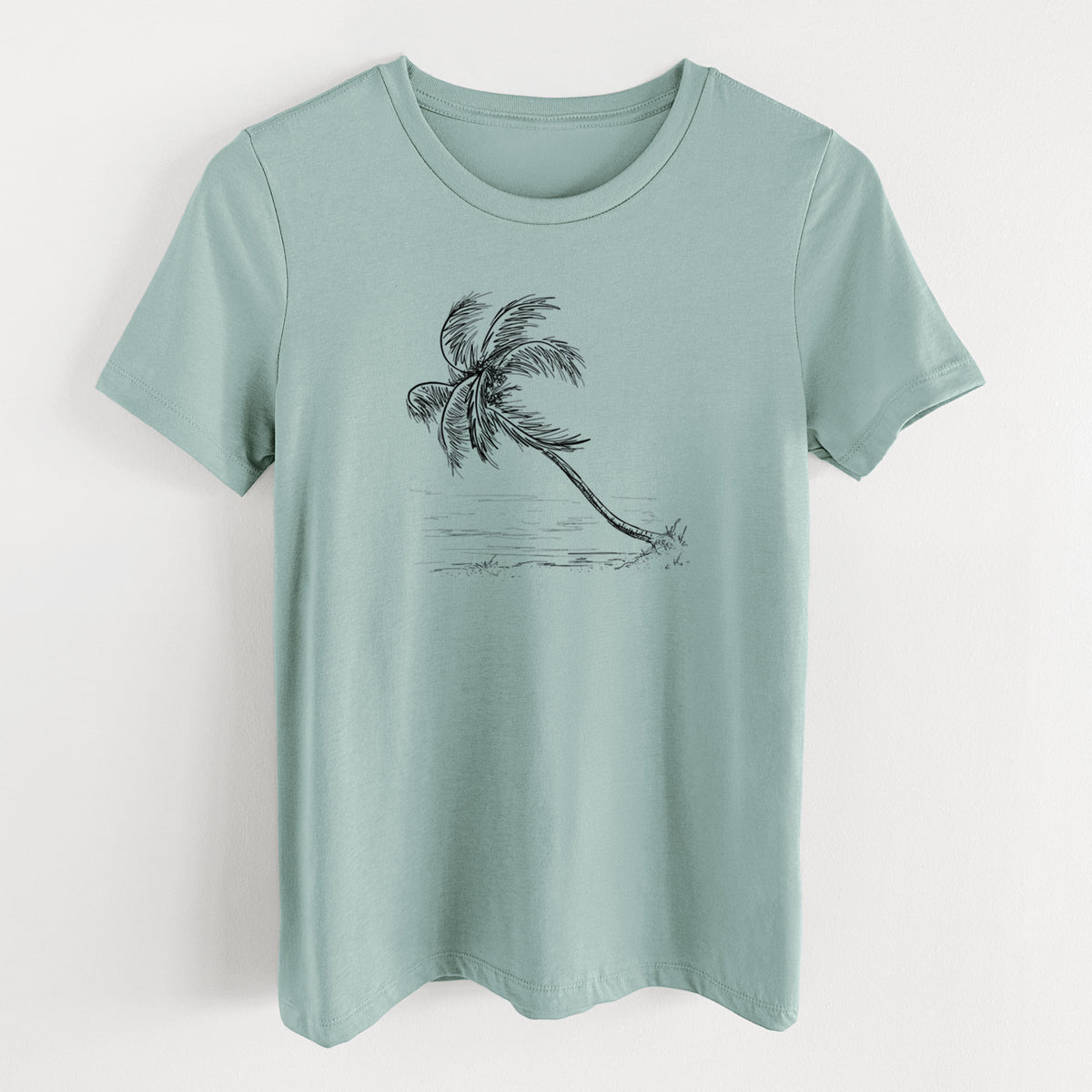 Dusty blue women's relaxed fit cotton t-shirt laid flat, printed with a black ink illustration of a coconut palm leaning over a sandy beach.
