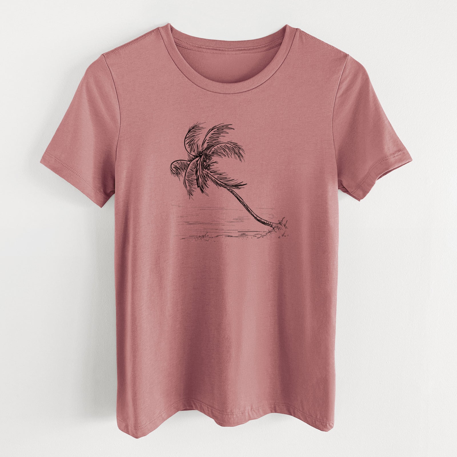 Mauve pink women's relaxed fit cotton t-shirt laid flat, printed with a black ink illustration of a coconut palm leaning over a sandy beach.