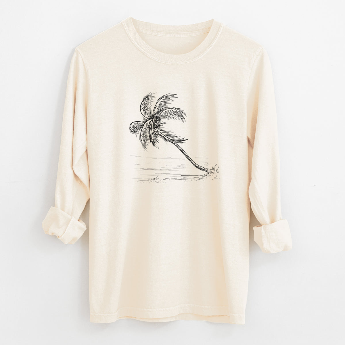 Ivory Comfort Colors long sleeve shirt laid flat with the cuffs rolled, printed with a black ink illustration of a coconut palm leaning over a sandy beach.
