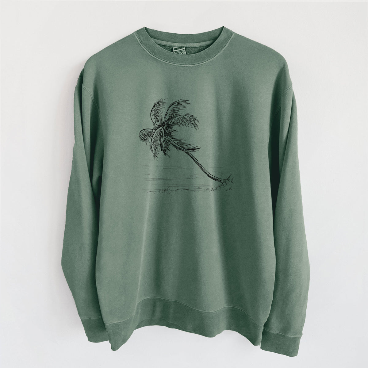 Alpine green pigment dyed crewneck sweatshirt laid flat, printed with a black ink illustration of a coconut palm leaning over a sandy beach.