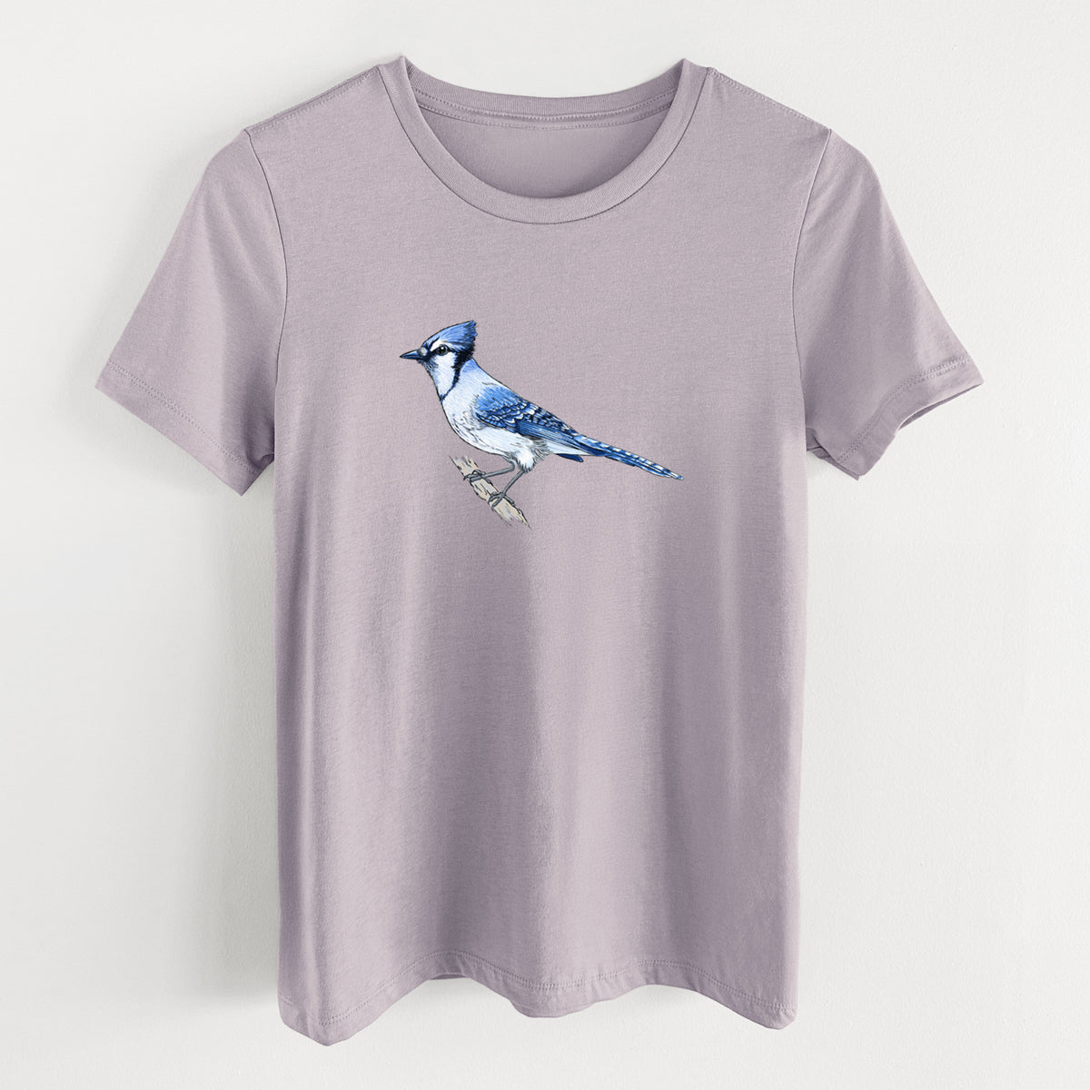Light violet women's relaxed fit cotton t-shirt laid flat, printed with a full-color illustration of a blue jay perched on a branch.